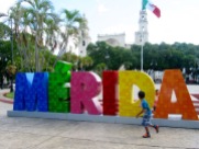 Des enfants s'amusent dans le parc et courent autour des fameuses lettres où les gens aiment se faire photographier. Mérida, Yucatán, Mexique.