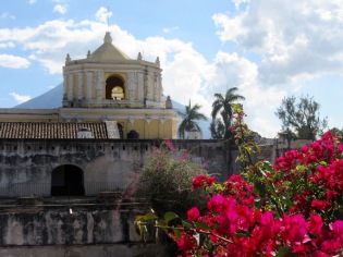 Du deuxième étage des ruines du couvent Nuestra Siñora De la Merced, nous apercevons l'église du même nom et l'un des trois volcans qui entourent la ville. Antigua, Guatemala.