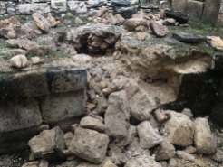 Le gardien du site nous explique qu'ils ne doivent pas essayer de réparer les dégâts des pilleurs, mais plutôt attendre la venue des archéologues afin qu'ils puissent numéroter les pierres avant d'amorcer les travaux et de tout replacer dans le bon ordre. (Photo de Robert) Aguateca, Petén, Guatemala.