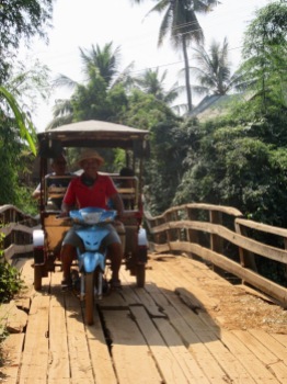 Ce pont de bois craquait de toutes ses planches, mais Sokcheat l'a emprunté sans aucune crainte. Kratie, Cambodge.