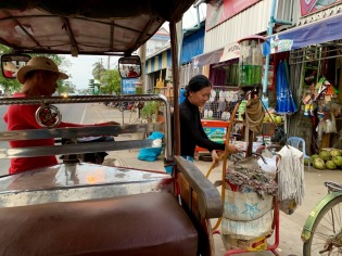 Sokcheat fait le plein d'essence pour sa moto à une pompe artisanale, mais très efficace. Chhlong, Cambodge.