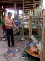 Le sirop de palme est bouilli sur un feu de bois. Lorsqu'il est suffisamment réduit, il est baratté à l'aide d'un dispositif artisanal et devient du sucre. Kratie, Cambodge.