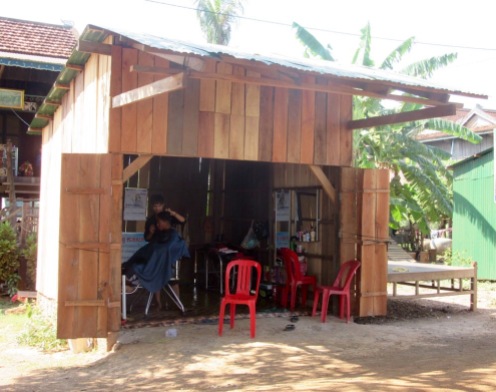 Un coquet salon de coiffure pour hommes, au bord de la route. Kratie, Cambodge.