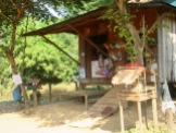 Un tout petit autel avec des offrandes est placé devant cette maison et son magasin, Kratie, Cambodge.