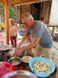 Robert prépare une banane qui sera trempée dans une pâte puis frite dans une grande marmite. Kratie, Cambodge.